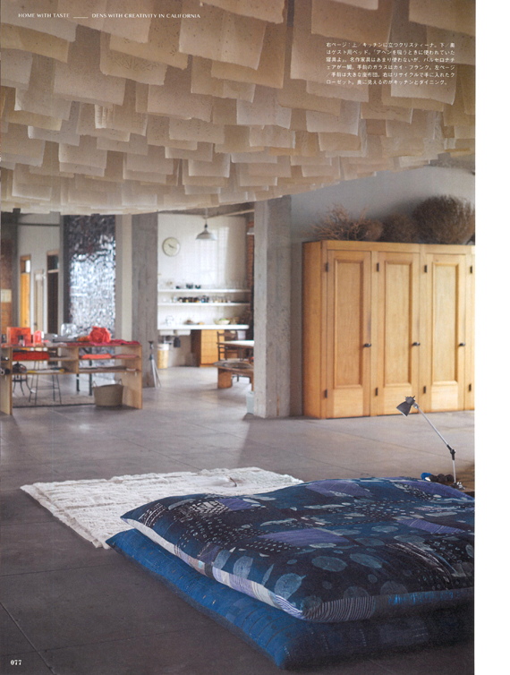 In the foreground is a large sitting pillow. To the right, a reclaimed closet. In the background, kitchen and dining areas are visible.