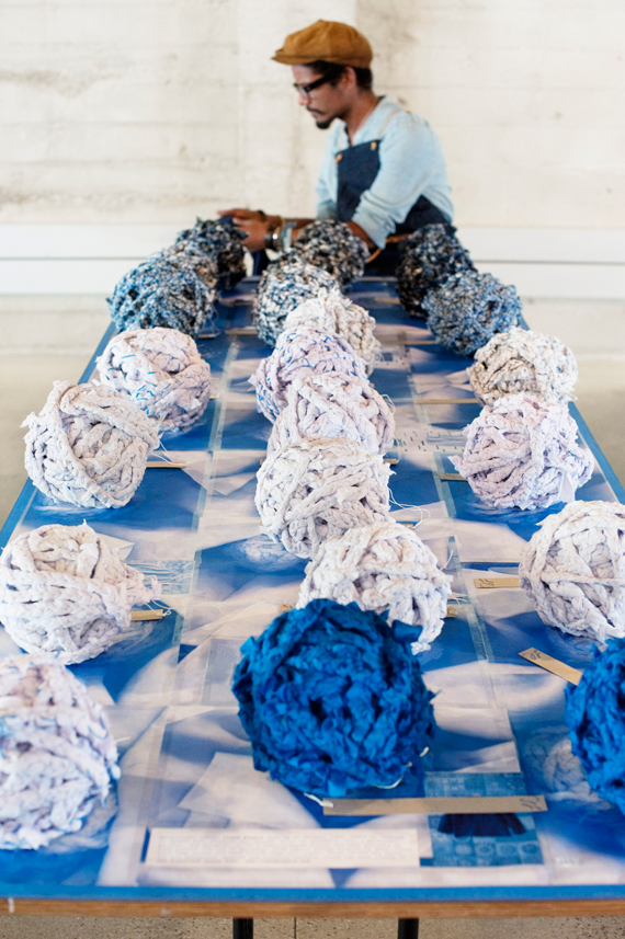 artist Llane Alexis works on-site braiding fabric sculptures from dosa scraps