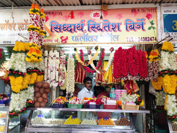 one of many vendors displays garlands and sweets 